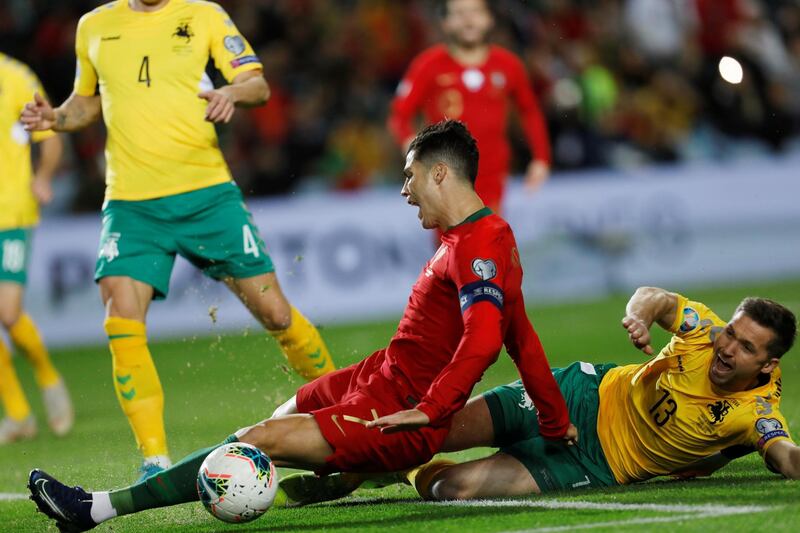 Cristiano Ronaldo is fouled by Lithuania's Saulius Mikoliunas, which resulted in a penalty. Reuters