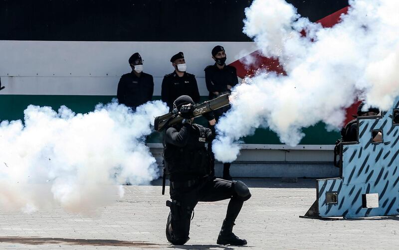 A Palestinian Hamas police cadet fires a weapon as he demonstrates his skills during a graduation ceremony in Gaza City. AFP