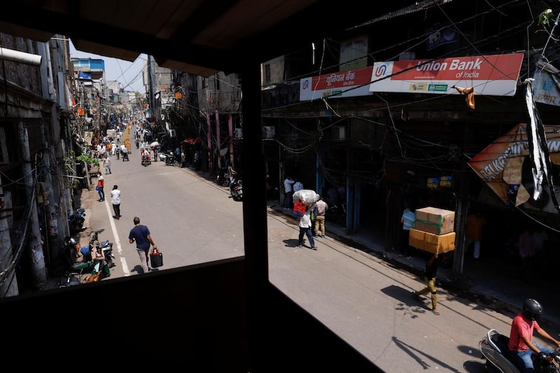 Workers carry goods at a market area in New Delhi.