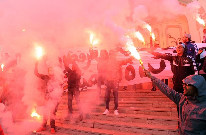 TOPSHOT - CORRECTION - Tunisian protesters carry flares and shout slogans during celebrations in central Tunis on January 14, 2018, marking the seventh anniversary since the uprising that ousted ex-president Zine El Abidine Ben Ali and launched the Arab Spring. / AFP PHOTO / Anis MILI / “The erroneous mention[s] appearing in the metadata of this photo by Anis MILI has been modified in AFP systems in the following manner: [celebrations marking the seventh anniversary since the uprising] instead of protest against the government over price hikes and austerity measures]. Please immediately remove the erroneous mention[s] from all your online services and delete it (them) from your servers. If you have been authorized by AFP to distribute it (them) to third parties, please ensure that the same actions are carried out by them. Failure to promptly comply with these instructions will entail liability on your part for any continued or post notification usage. Therefore we thank you very much for all your attention and prompt action. We are sorry for the inconvenience this notification may cause and remain at your disposal for any further information you may require.”