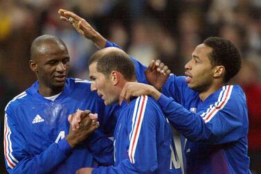 FILE PHOTO: ON THIS DAY -- March 27 March 27, 2002 SOCCER - Zinedine Zidane celebrates with team mates Thierry Henry and Patrick Vieira after scoring a goal in a friendly against Scotland where France won 5-0 at the Stade de France. Zidane opened the scoring for the defending world champions after which a David Trezeguet brace and a goal apiece from Patrick Vieira and Steve Marlet sealed the win. The game was part of France's preparations for their World Cup title defence two months later, but they spectacularly exited the tournament in the group stage after defeats by Senegal and Denmark and a draw with Uruguay. REUTERS/Charles Platiau/File Photo