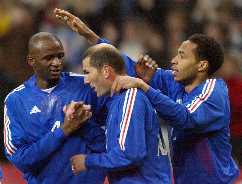 FILE PHOTO: ON THIS DAY -- March 27  March 27, 2002      SOCCER - Zinedine Zidane celebrates with team mates Thierry Henry and Patrick Vieira after scoring a goal in a friendly against Scotland where France won 5-0 at the Stade de France.      Zidane opened the scoring for the defending world champions after which a David Trezeguet brace and a goal apiece from Patrick Vieira and Steve Marlet sealed the win.      The game was part of France's preparations for their World Cup title defence two months later, but they spectacularly exited the tournament in the group stage after defeats by Senegal and Denmark and a draw with Uruguay. REUTERS/Charles Platiau/File Photo