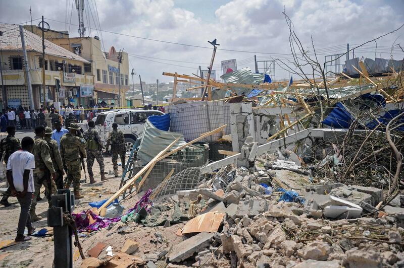 Somali security force personnel walk among debris at the site of a car bomb explosion near the building of the Interior Ministry in Mogadishu on July 7, 2018. Two explosions have rocked Somalia's internal security ministry in the capital Mogadishu, killing five civilians, a police officer said, in the latest attack claimed by Shabaab militants. / AFP / Mohamed ABDIWAHAB               
