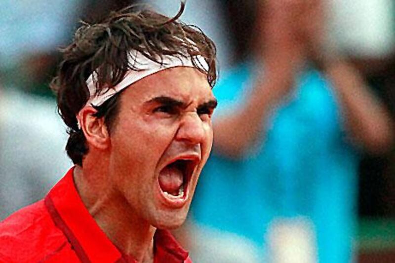 Roger Federer reacts after defeating Novak Djokovic at the Roland Garros stadium in Paris.