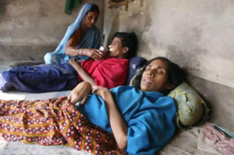 Ansara Bibi takes care of her two daughters, Rezina, foreground, and Fatema, who have both been bedridden since birth.