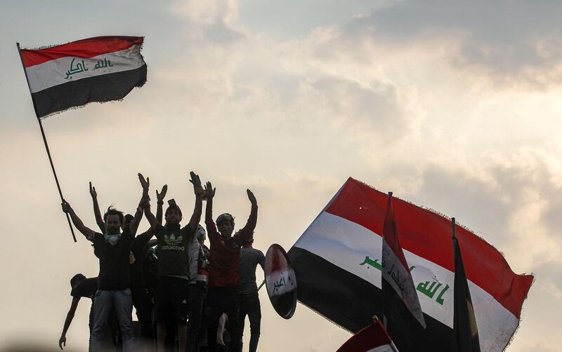 Iraqis wave national flags during a demonstration along Al Jumhuriya Bridge in Baghdad. AFP