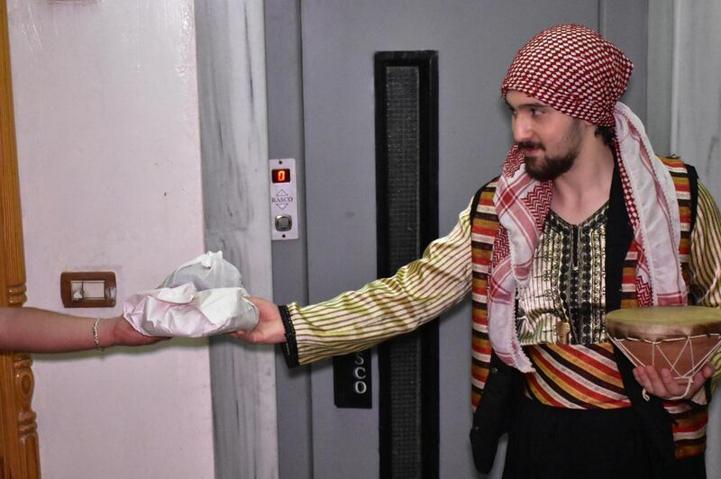 A Syrian man gives food to the Mosaharati in Damascus. Syria has alleviated the curfew imposed on the country to prevent the spread of the coronavirus and reopened religious places for the first time during Ramadan. EPA