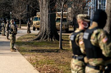 Military police and trucks stand on guard near the Capitol Building on Capitol Hill in Washington on January 14, 2021. AP
