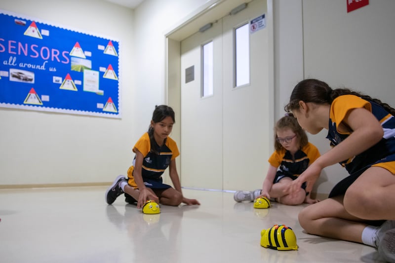 Pupils with the little yellow robots at Repton Al Barsha.