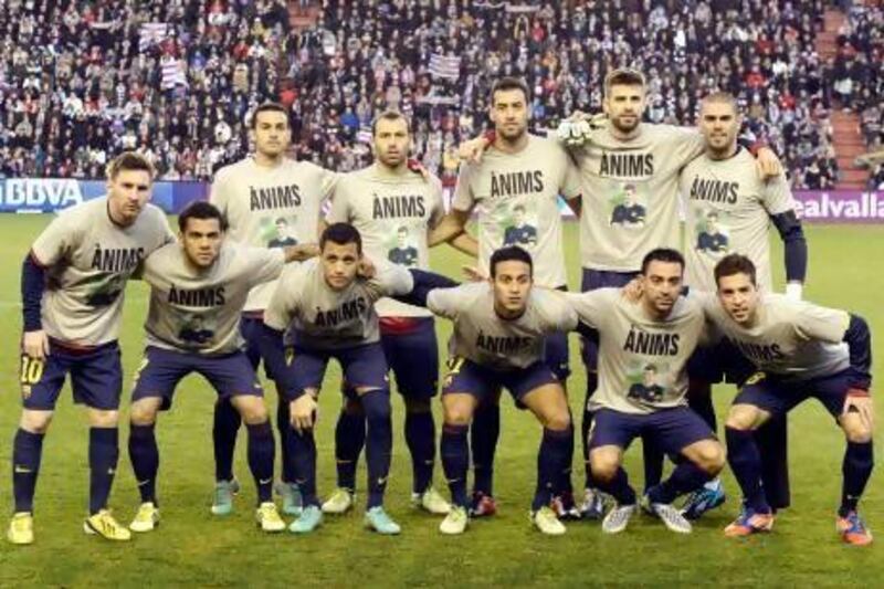 Barcelona's players pose jerseys featuring the portrait of their head coach, Tito Vilanova, reading 'Come on!', in Catalonian, prior to their Primera Liga match with Valladolid.