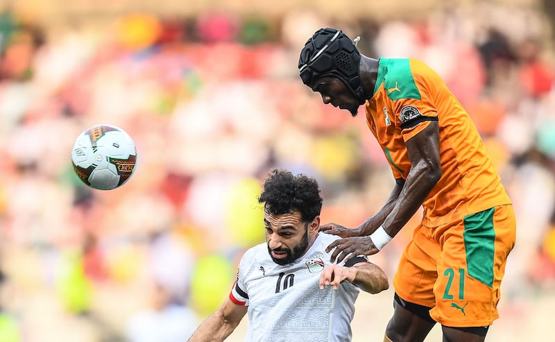 Ivory Coast defender Eric Bailly heads the ball under pressure from Mohamed Salah. AFP