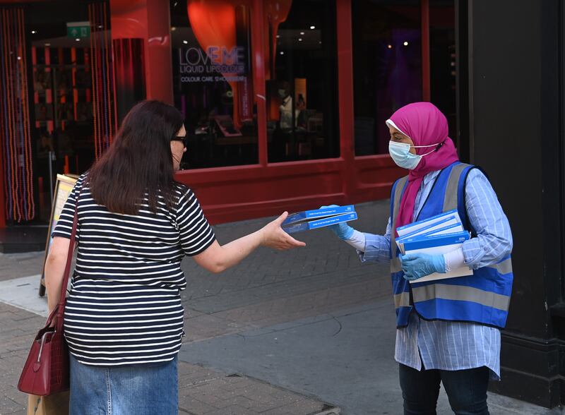 A worker offers free Rapid Antigen tests to members of the public in Carnaby Street in London.
