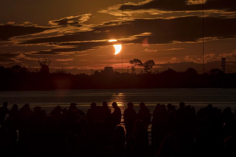 People observe the partial solar eclipse, in Porto Alegre, Brazil.  EPA