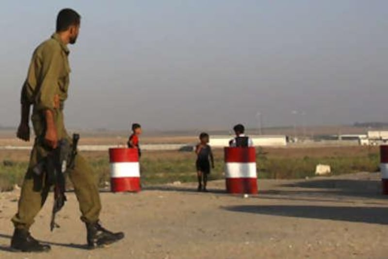 A Palestinian security forces officer from Hamas guards the main road leading to the Karni Cargo Crossing. Gaza is to receive its first shipment of cement in a year today.