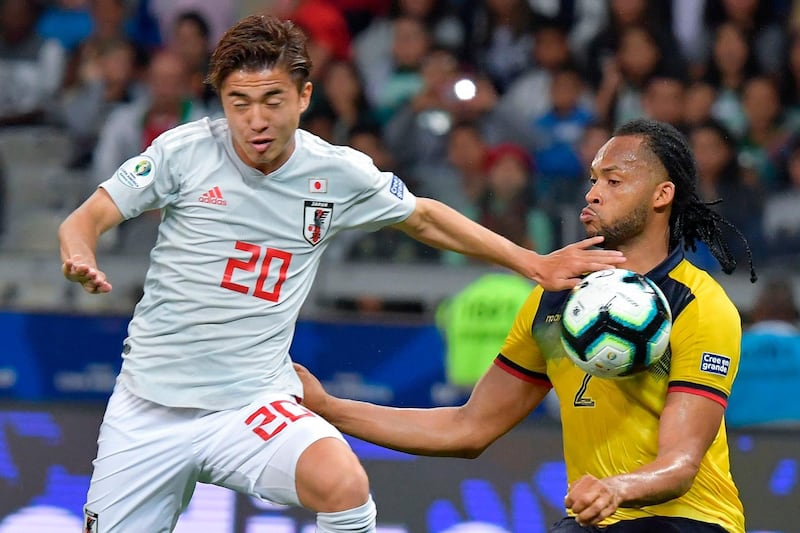 Japan's Hiroki Abe, left, and Ecuador's Arturo Mina vie for the ball. AFP