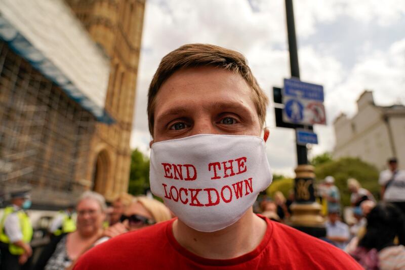 A man wears a mask reading 'End the lockdown' outside the Palace of Westminster, to protest against the delay of the planned relaxation of lockdown measures, in London. AP Photo