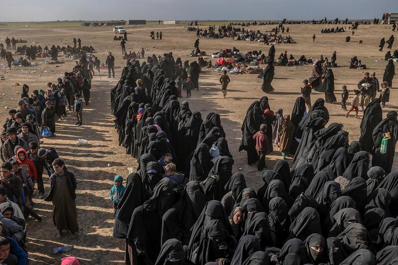 TOPSHOT - Civilians evacuated from the Islamic State (IS) group's embattled holdout of Baghouz wait at a screening area held by the US-backed Kurdish-led Syrian Democratic Forces (SDF), in the eastern Syrian province of Deir Ezzor, on March 5, 2019. Kurdish-led forces launched a final assault Friday on the last pocket held by the Islamic State group in eastern Syria, their spokesman said. The "operation to clear the last remaining pocket of ISIS has just started", Mustefa Bali, the spokesman of the US-backed Syrian Democratic Forces, said in a statement using an acronym for the jihadist group. / AFP / Bulent KILIC
