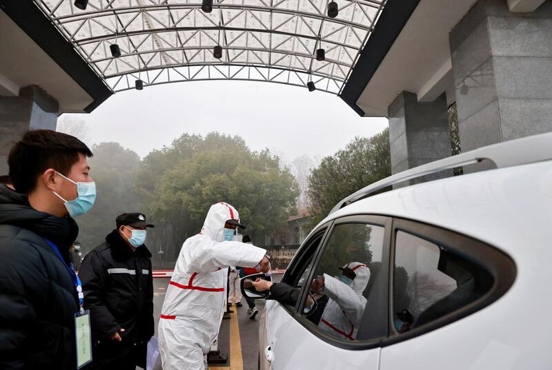 Security personnel check people's temperature during the visit by members of the World Health Organisation team. Reuters