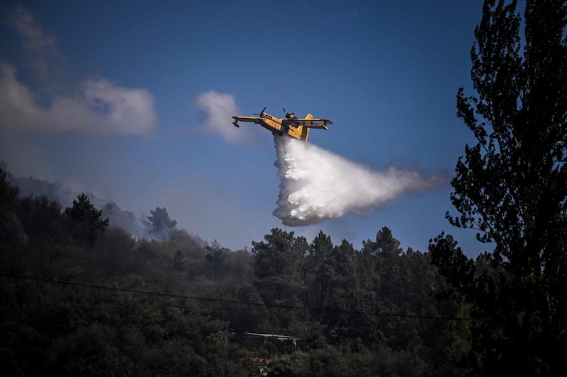 A Canadair firefighter plane drops water on the flames at Orjais. AFP