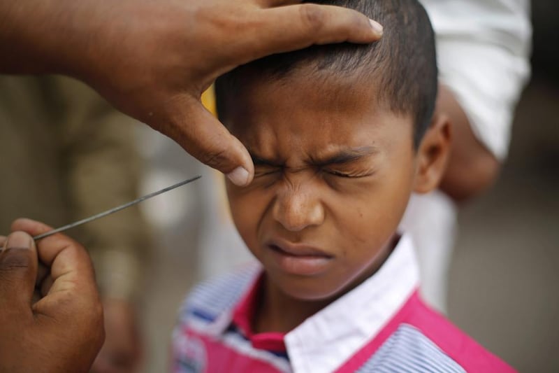 An Indian Muslim boy reacts as a man applies Kohl, an eye cosmetic on his eye after prayers during Eid al-Adha, or the Feast of the Sacrifice, in Mumbai, India, Wednesday, Oct. 16, 2013. Eid al-Adha is a religious festival celebrated by Muslims worldwide to commemorate the willingness of Prophet Ibrahim to sacrifice his son as an act of obedience to God. (AP Photo/Rafiq Maqbool) *** Local Caption ***  India Eid al Adha.JPEG-0bd25.jpg