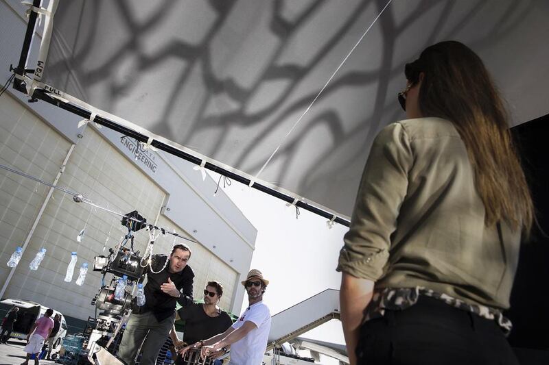 A stand-in actor poses for cameras as she and production staff set up another shot ahead of Kidman’s advertisement shoot at the Etihad hangars at the Abu Dhabi International Airport.