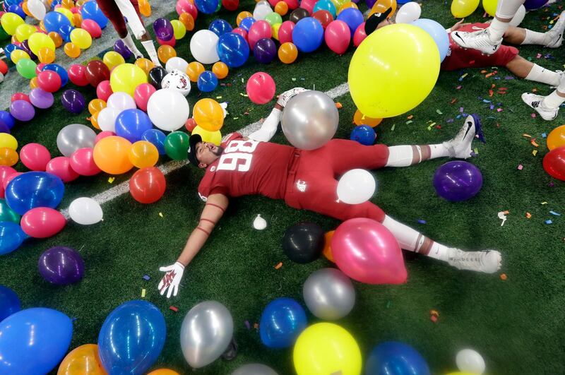 Washington State defensive lineman Dallas Hobbs rolls between balloons as he he celebrates the team's 28-26 win over Iowa State in the Alamo Bowl NCAA college football in San Antonio, Texas. AP Photo