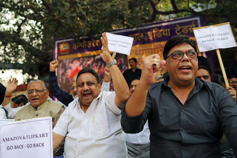 Merchants display placards and shout slogans during a sit-in protest at Sadar Bazaar in New Delhi, India, on Wednesday, Nov. 20, 2019. In the heart of New Delhi's largest wholesale bazaar, merchants who normally compete with each other have united against a common enemy. The sit-in, which created more chaos than usual among the rickshaws, motorbikes and ox-carts plying the market road, was one of as many as 700 protests against Amazon.com Inc. and Walmart Inc. -- owner of local e-commerce leader Flipkart -- that organizers say took place at bazaars across India on a recent Wednesday. Photographer: Anindito Mukherjee/Bloomberg
