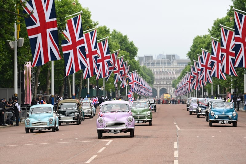 Vintage cars in front of Buckingham Palace during the London pageant. PA