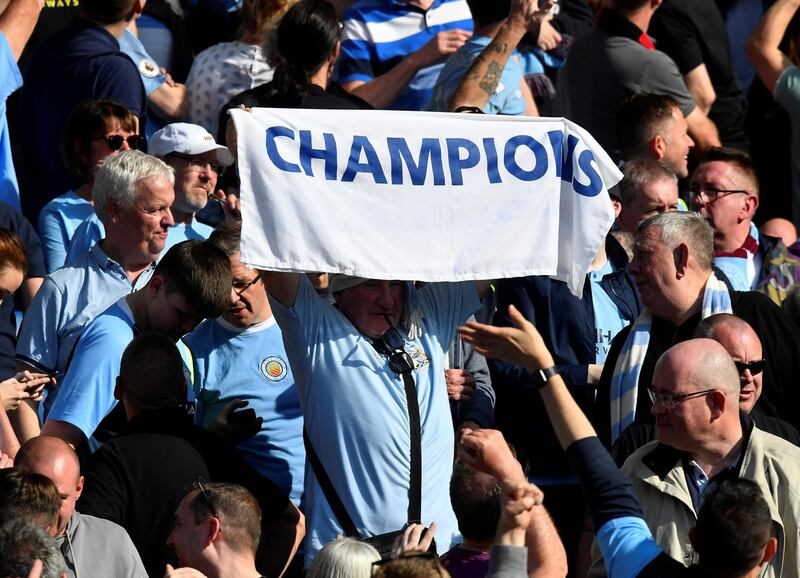 Manchester City fan holds up a banner as they celebrate winning the Premier League title. Reuters