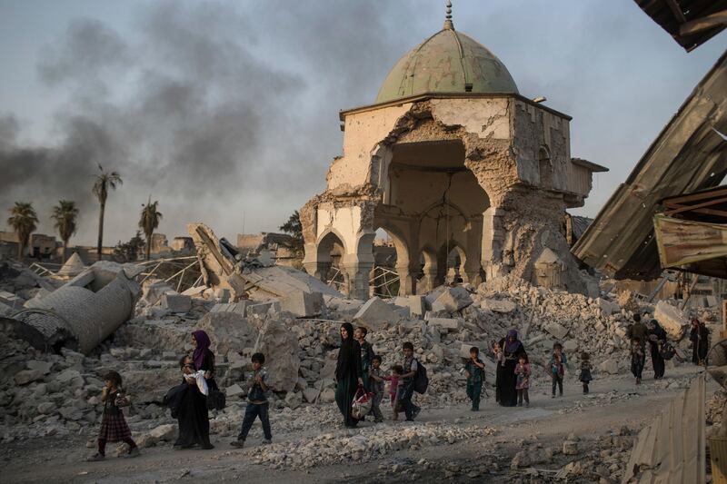 Fleeing Iraqi civilians walk past the heavily damaged Al Nuri mosque as Iraqi forces continue their advance against ISIL in the Old City of Mosul, Iraq, Tuesday, July 4, 2017. AP / Felipe Dana)