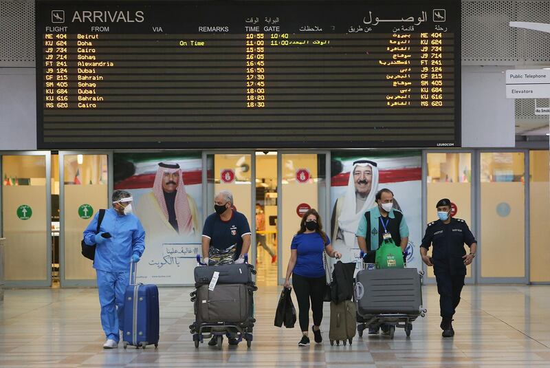 Travellers arrive at Kuwait international Airport, in Farwaniya, about 15kms south of Kuwait City, on August 1, 2020.  Commercial flights resumed at Kuwait International Airport today after months of shut down due to the COVID-19 pandemic. / AFP / YASSER AL-ZAYYAT
