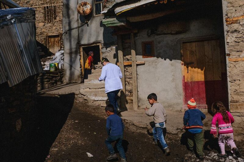 Children in Guneyammac follow Akay Kaya, a doctor from Bahcesaray public hospital, as he tries to vaccinate residents 65 and older against Covid-19. AFP