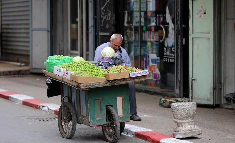 Palestinian vendor waits for customers during the Islamic holy month of Ramadan, in the West Bank city of Nablus.  EPA