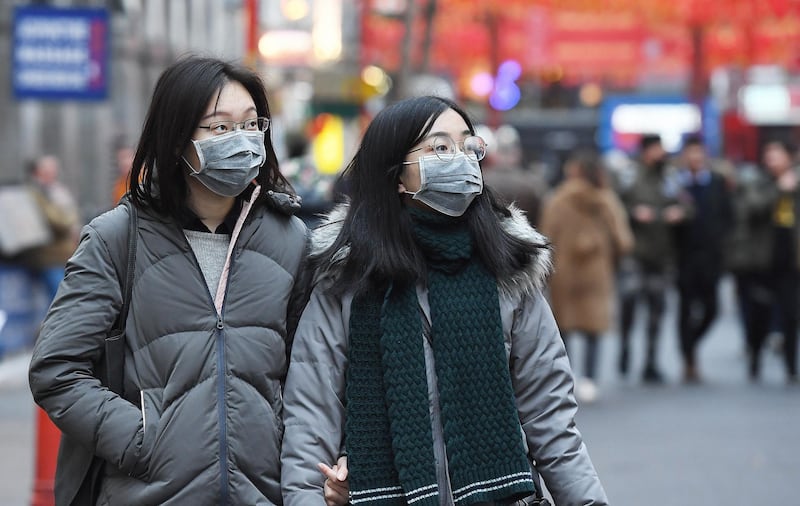 epa08155268 People wear face masks in London, Britain, 23 January 2020. British Health Secretary Matt Hancock has stated that the Corona virus may already be in Britain.  EPA/ANDY RAIN