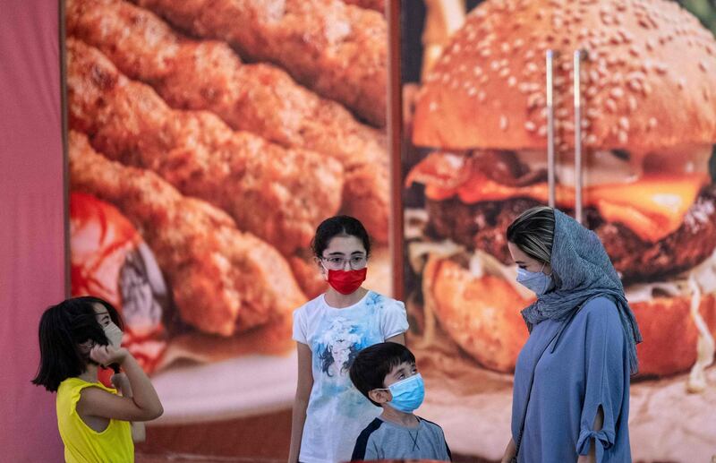 An Iranian woman and children stand in front of a fast-food shop at the Grand Bazaar in the capital Tehran. AFP