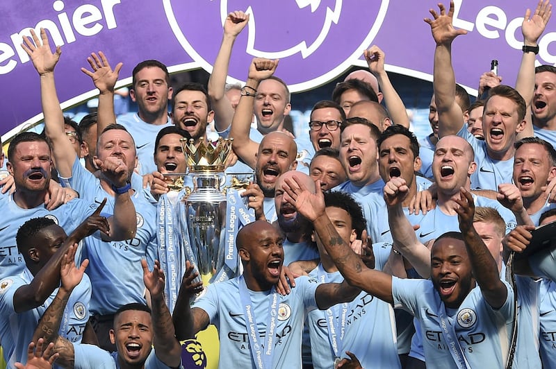 Manchester City's Spanish manager Pep Guardiola (C) holds the Premier League trophy on the pitch with Manchester City players after the English Premier League football match between Manchester City and Huddersfield Town at the Etihad Stadium in Manchester, north west England, on May 6, 2018. (Photo by Oli SCARFF / AFP) / RESTRICTED TO EDITORIAL USE. No use with unauthorized audio, video, data, fixture lists, club/league logos or 'live' services. Online in-match use limited to 75 images, no video emulation. No use in betting, games or single club/league/player publications. / 