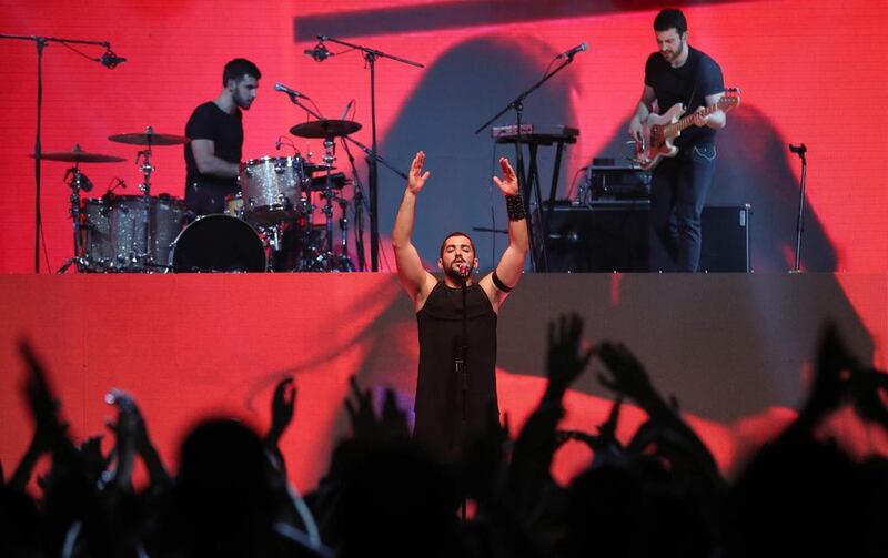 Hamed Sinno, the lead singer of Lebanese band Mashrou Leila, performs on stage at the Dubai International Marine Club. Courtesy AFP / KARIM SAHIB

