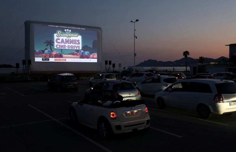 FILE PHOTO: People sit in their cars to watch the movie "E.T. the Extra-Terrestrial" by Steven Spielberg at a drive-in cinema at la Pointe Croisette, during the coronavirus disease (COVID-19) outbreak, in Cannes, France May 20, 2020. REUTERS/Eric Gaillard/File Photo