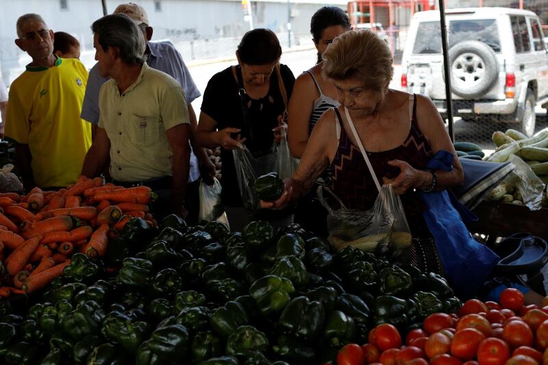 A woman selects peppers at a vegetable and fruit stall at a street market in Caracas, Venezuela October 8, 2018. REUTERS/Marco Bello