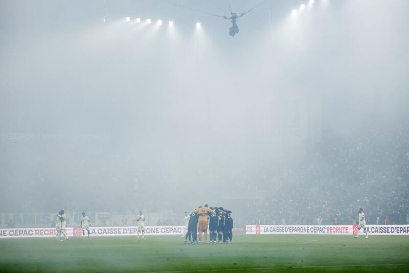 PSG players huddle in the fog prior the French Ligue 1 match against Olympique Marseille in Marseille, France. EPA