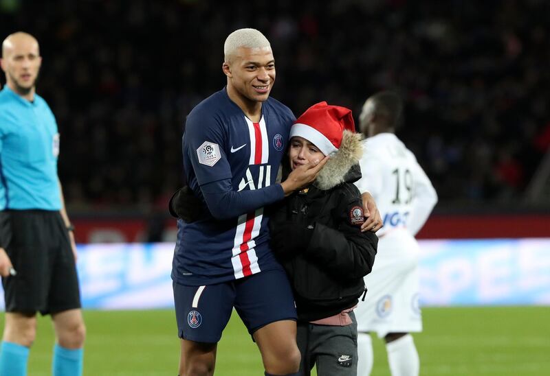 PSG's Kylian Mbappe calms the youngster after he stopped the game. AP