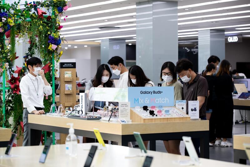 Customers wearing protective masks try out Samsung Galaxy Tab tablet devices at the company's Digital Plaza store in Seoul, South Korea. Bloomberg