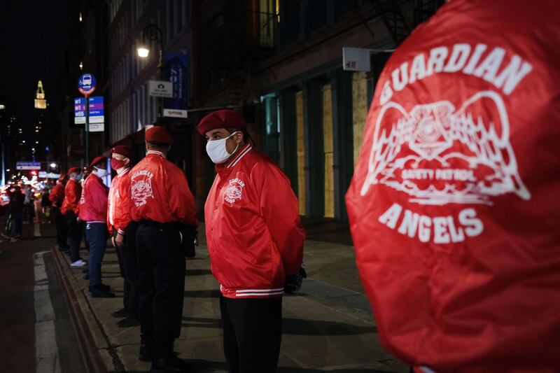 Members of the Guardian Angels, a volunteer organisation of unarmed citizens which began in the late 1970s, stand guard near looted stores during a night of protests and vandalism over the death of George Floyd, in New York City. Getty