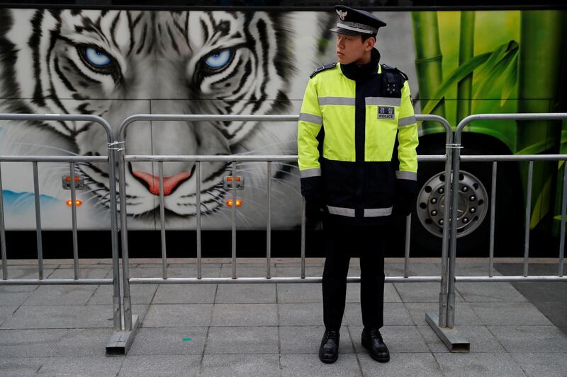 A policeman waits for the convoy to pass.