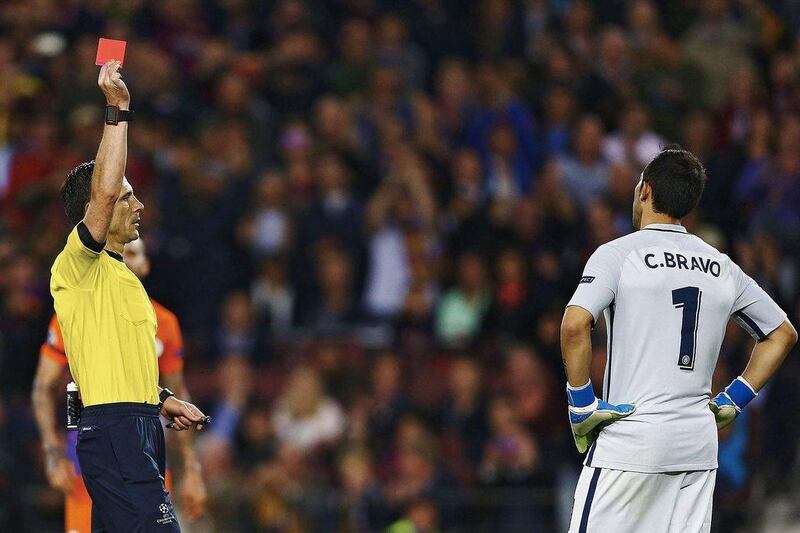 Referee Milorad Mazic, left, shows a red card to Manchester City’s goalkeeper Claudio Bravo. Alejandro Garcia / EPA