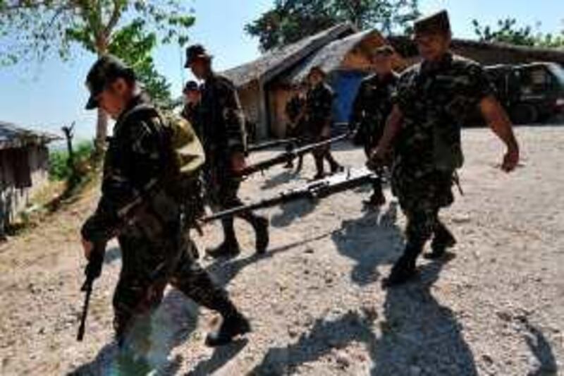Philippines soldiers carry .50 caliber machine guns unearthed at a property believed to be owned by the governor of Maguindanao at a military camp in Shariff Aguak southern Philippines province of Maguindanao on December 7, 2009, the first day of office after the government declared martial law in the province.  The Philippine military said December 7 its troops are hunting down 3,000 armed followers of a powerful Muslim clan whose provincial stronghold was placed under martial law after its leaders were accused of a brutal massacre.    AFP PHOTO/TED ALJIBE *** Local Caption ***  395527-01-08.jpg