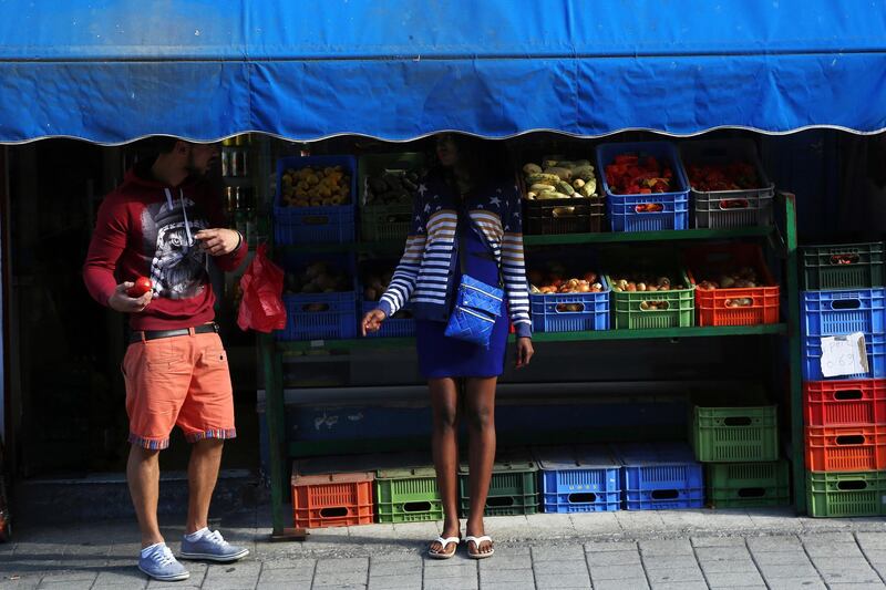 In this Friday, Nov. 16, 2018, migrants stand at a market stall in central Nicosia, Cyprus. Cyprus was not seen as an attractive destination for migrants seeking shelter and a new life in Europe, but that has changed as other nations in Europe have shut their borders and the economic situation has slowly improved for this small island nation.(AP Photo/Petros Karadjias)