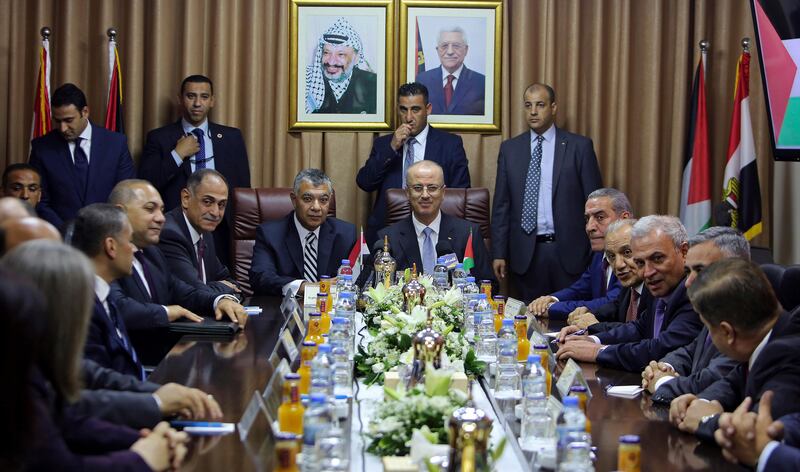 Palestinian Prime Minister Rami Hamdallah, center, and Egyptian intelligence chief Khaled Fawzy, center left, head a meeting with officials at Palestinian President Mahmoud Abbas' former official residence, in Gaza City, Tuesday, Oct. 3, 2017. A new round of Palestinian reconciliation talks has experienced its first sign of trouble as the Hamas militant group says it will not give up its vast weapons arsenal, putting it at odds with both the rival Fatah movement and Israel. (AP Photo/Prime Minister Office)