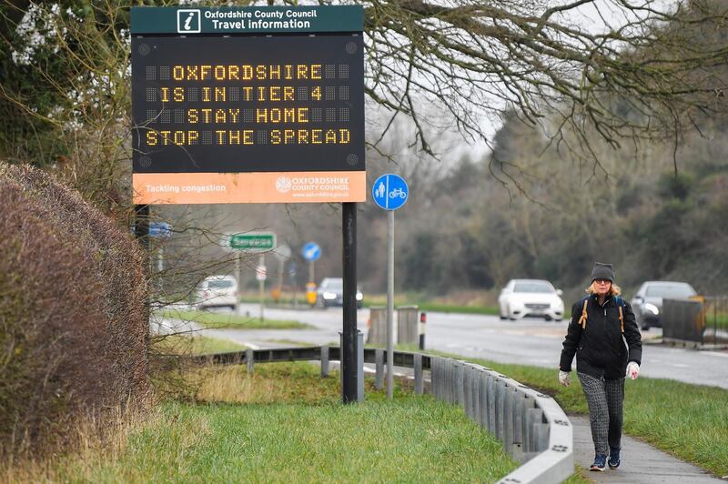 A person walks past a roadside public health information sign near Oxford. Reuters