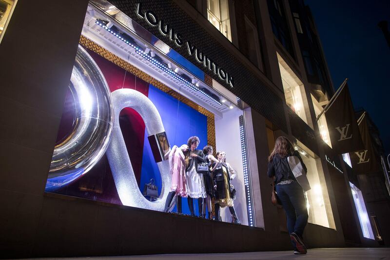 A pedestrian walks past a display of luxury fashion apparel in the window of a LVMH Moet Hennessy Louis Vuitton SE store on New Bond Street in central London, U.K., on Thursday, Aug. 31, 2017. U.K. consumer confidence staged a slight rebound from its lowest level since just after the Brexit vote. Photographer: Simon Dawson/Bloomberg